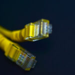 Yellow RJ-45 or ethernet internet cable on black background