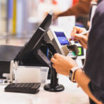 Consumer's women signing on a touch screen of credit card transaction machine at supper market